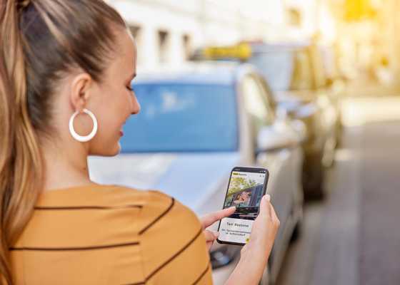 Fahrgästin bestellt ein Taxi per Smartphone